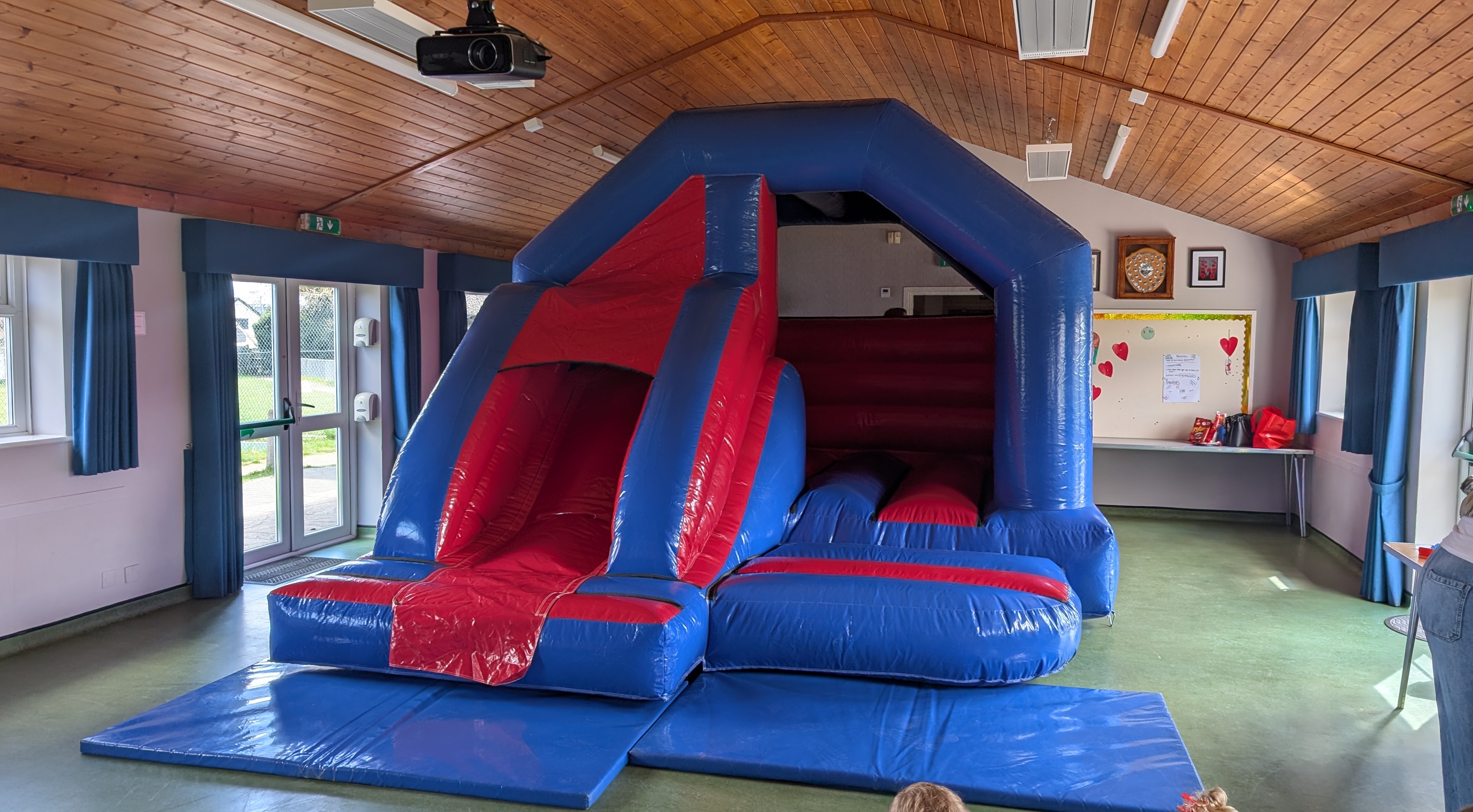 Bouncy castle with slide set up inside Elsenham Memorial Hall