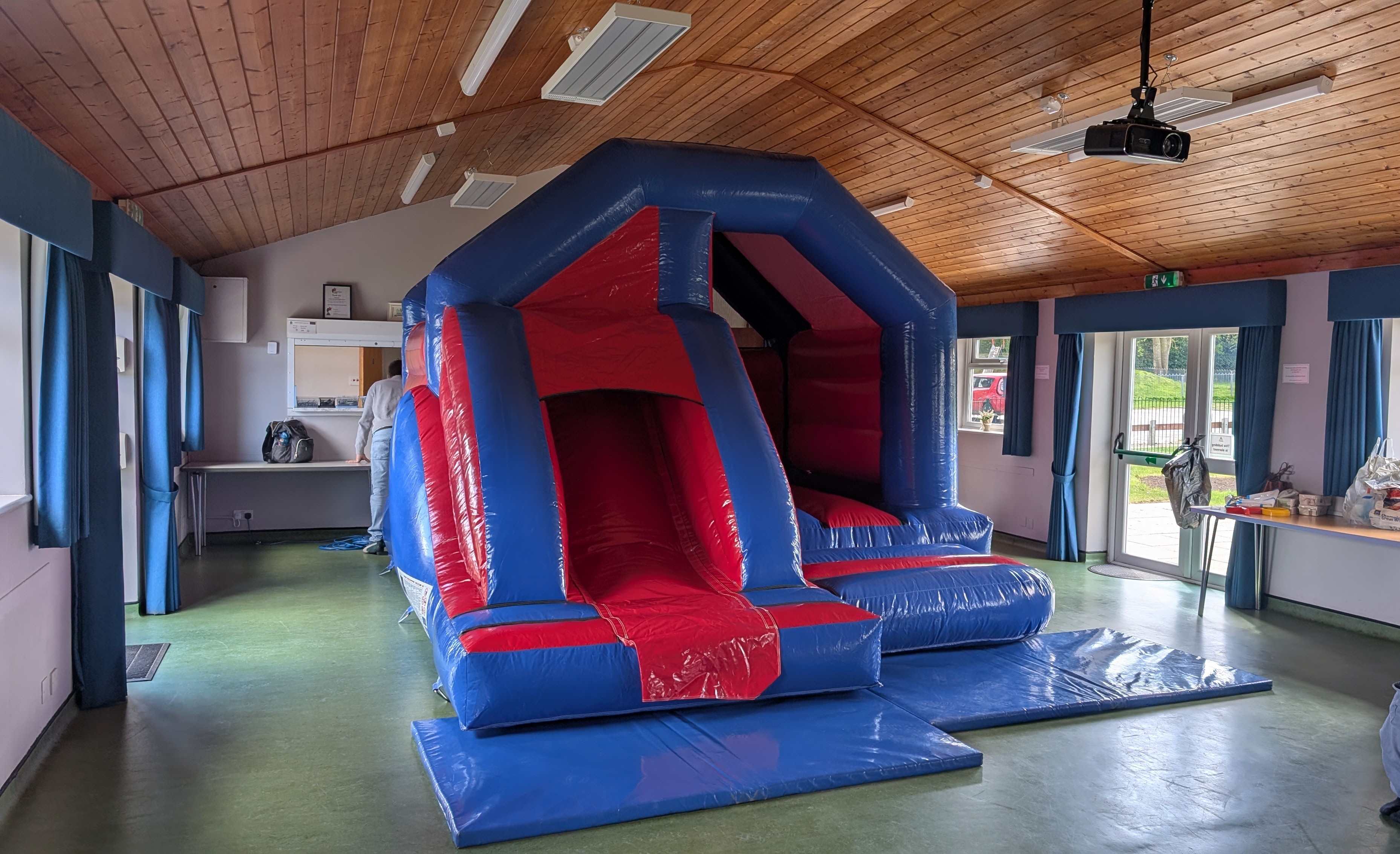 Red & blue bouncy castle with slide inside Elsenham Memorial Hall
