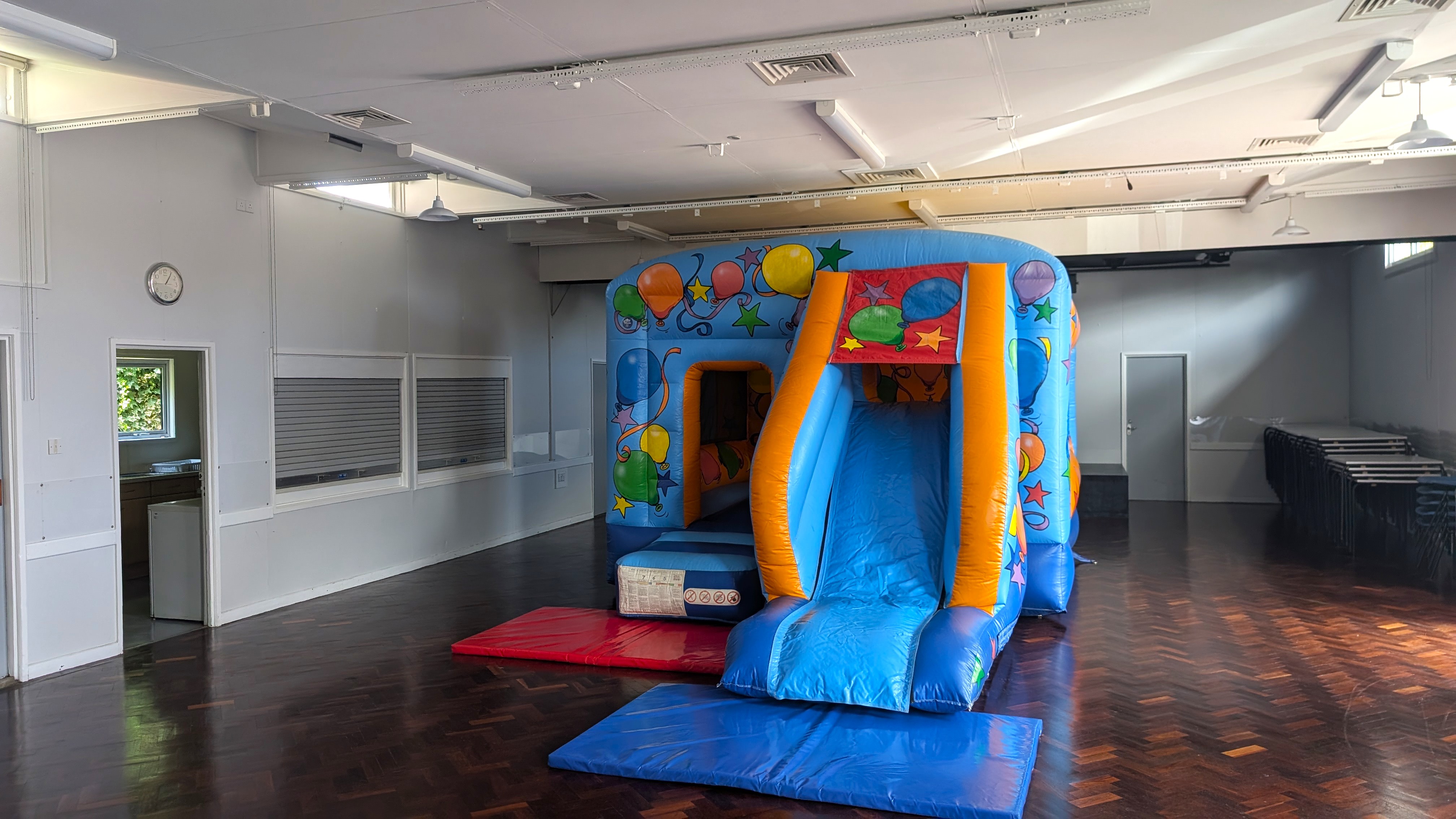 Perfect indoor setup for parties at Hatfield Heath Village Hall Deluxe party bouncy castle with slide inside Hatfield Heath Village Hall
