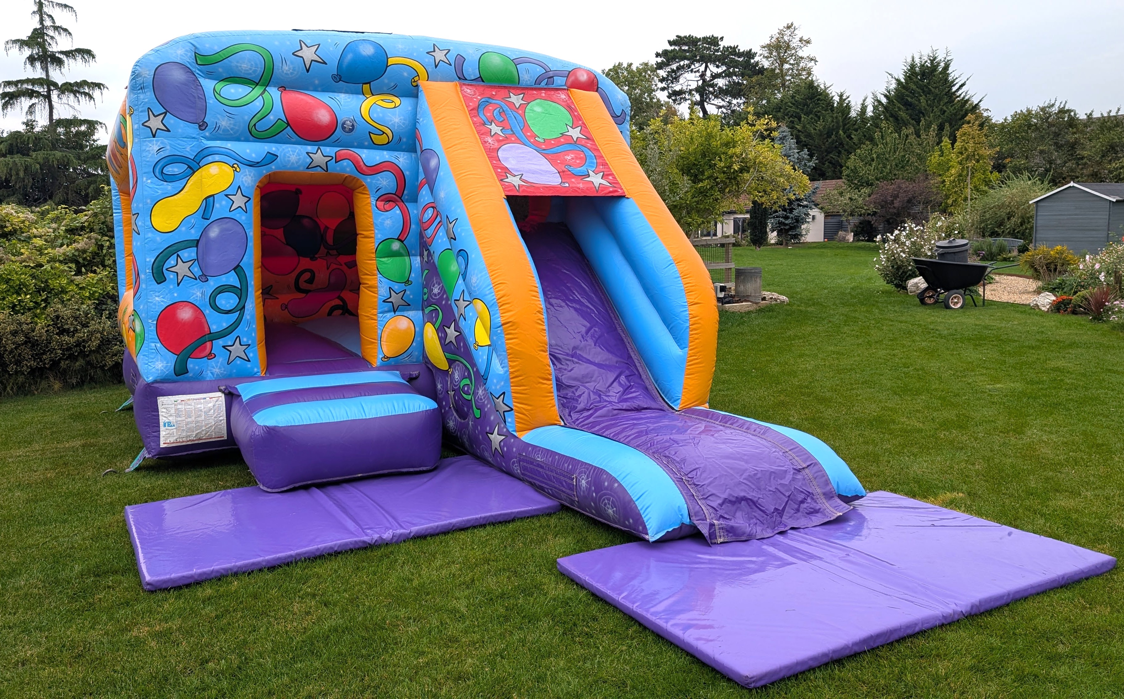 Deluxe Party Bouncy Castle with Slide Hire – Outdoor Setup Deluxe party bouncy castle with slide hire set up in a garden in Harlow