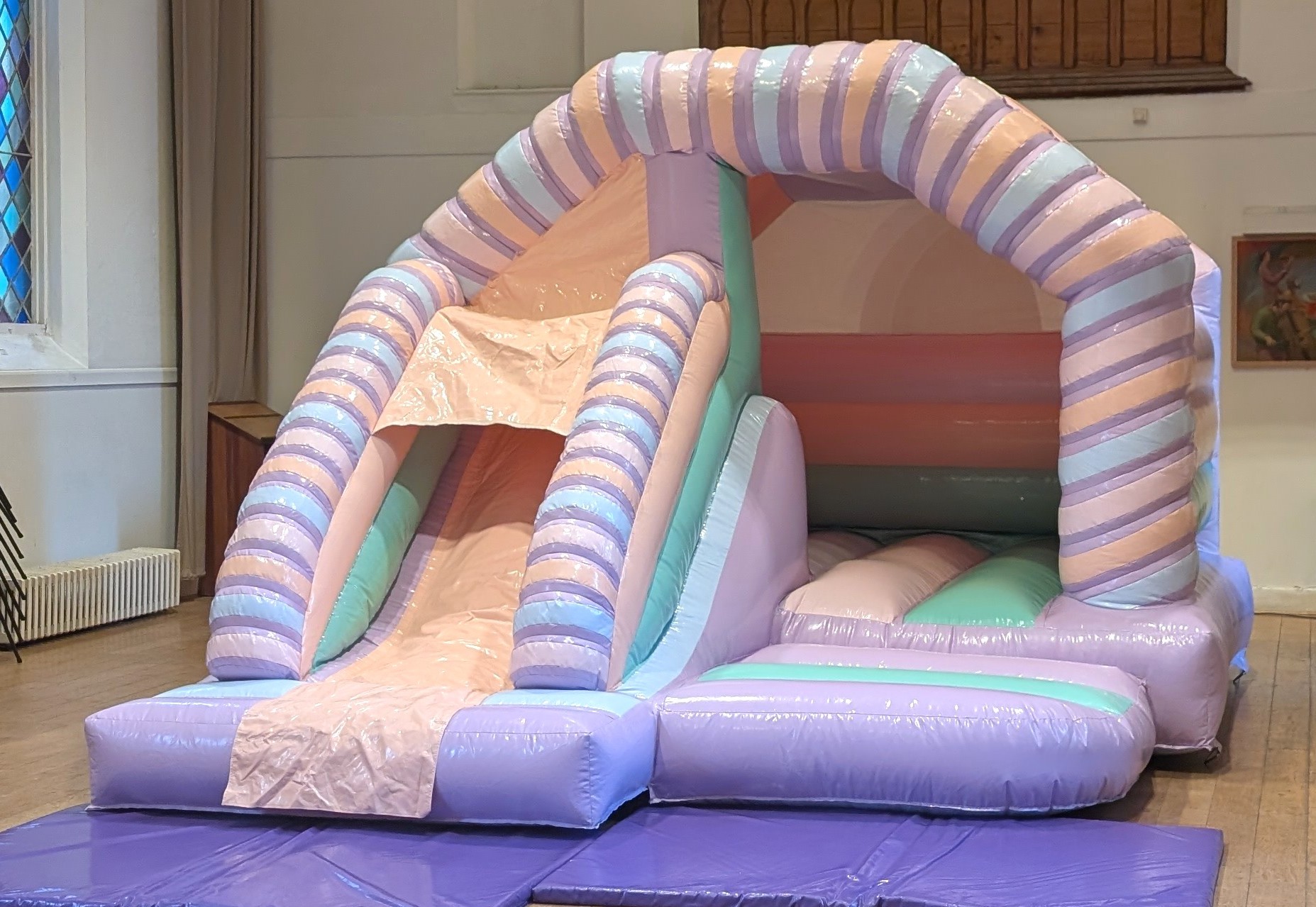 Pastel bouncy castle with slide hire in Hall indoor setup